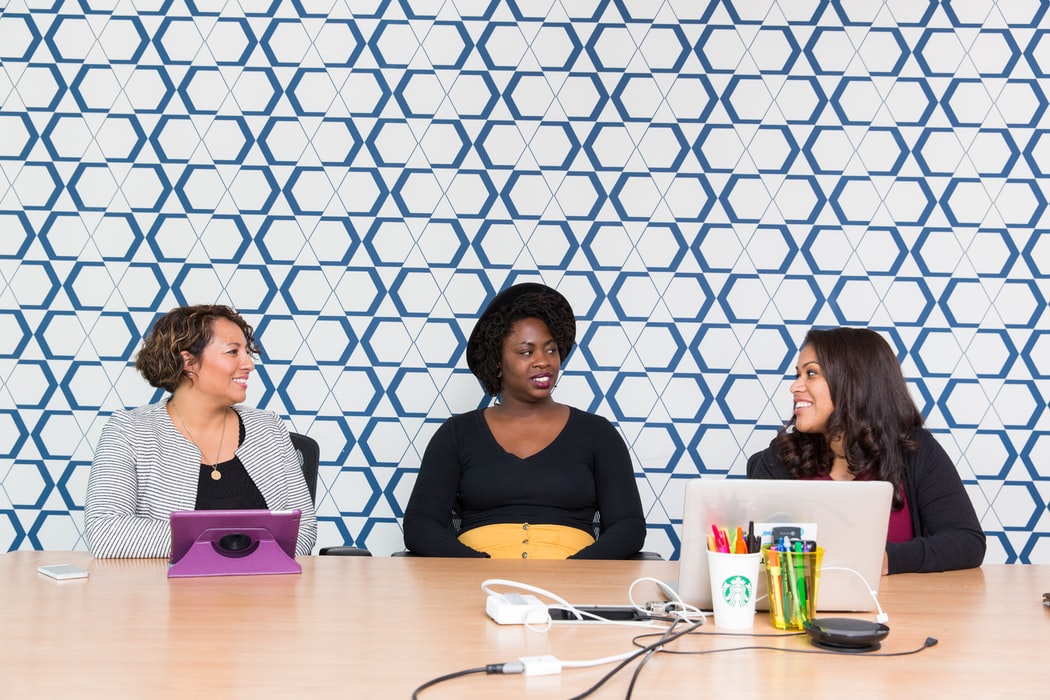 Three women of color discussing employee resource group tasks